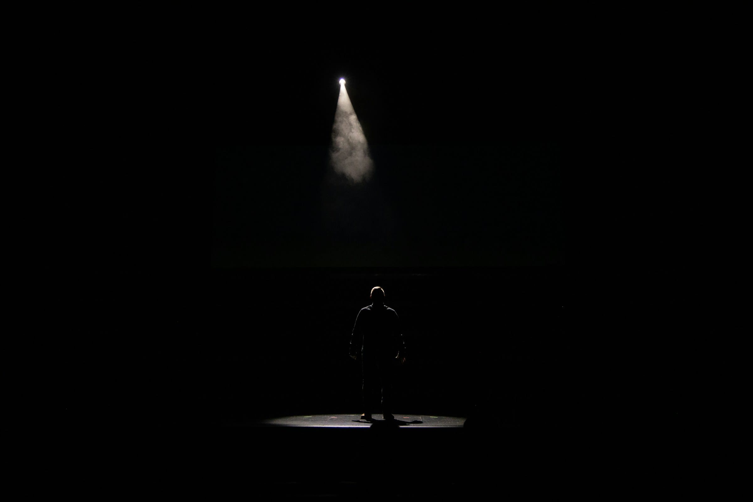 A single figure under a spotlight