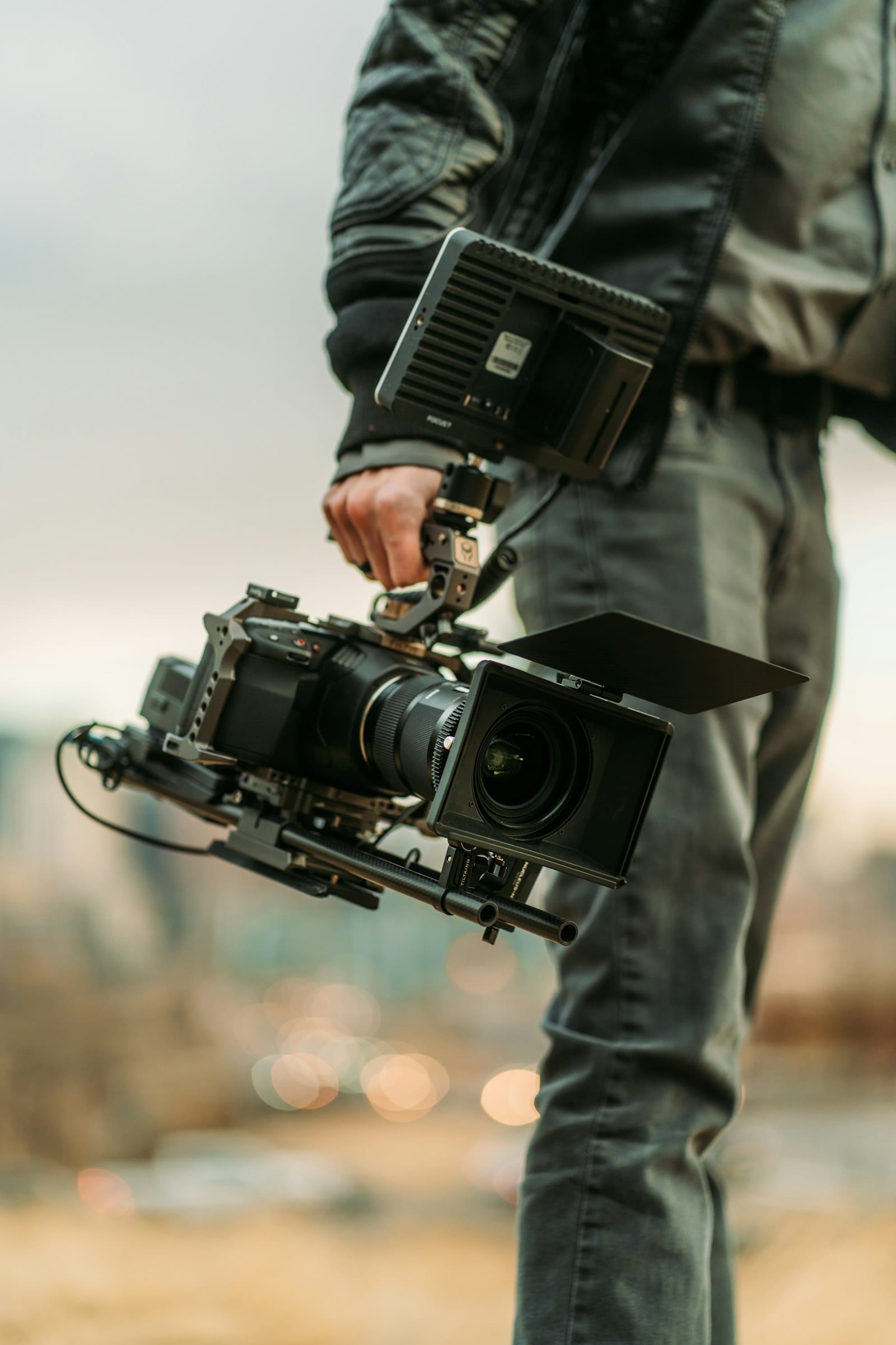 man in black jacket holding black dslr camera