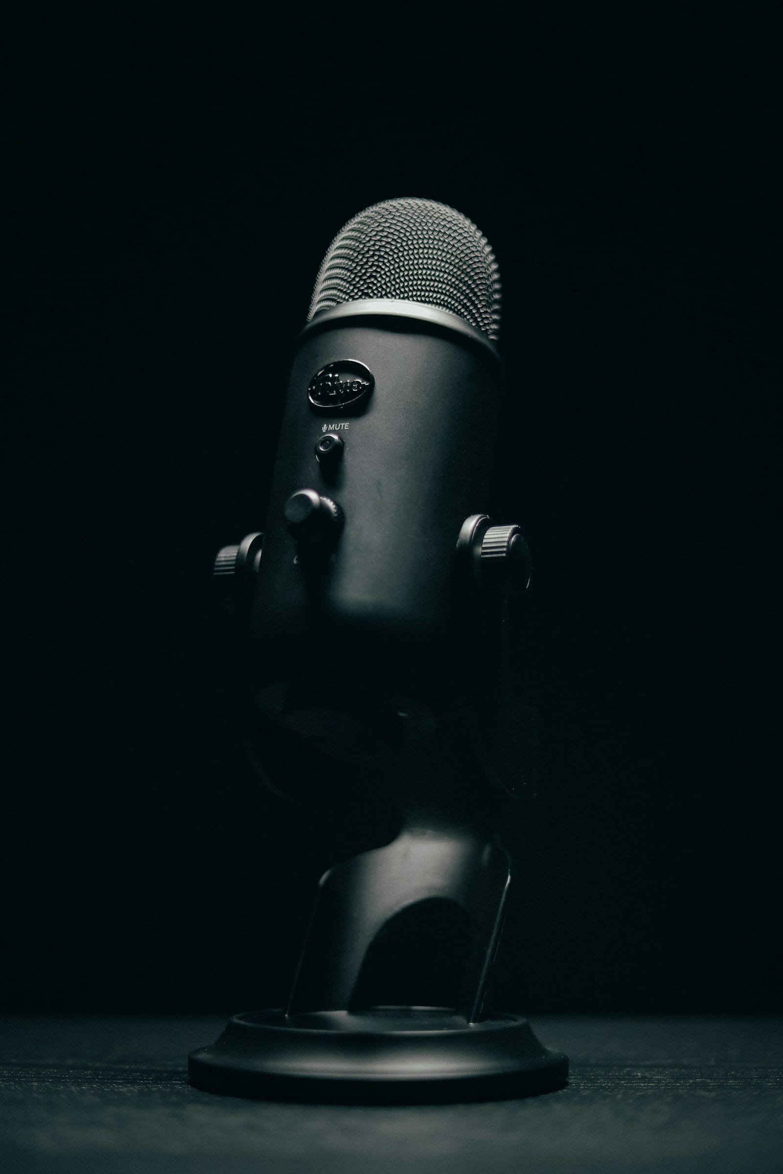 black microphone with stand on black background