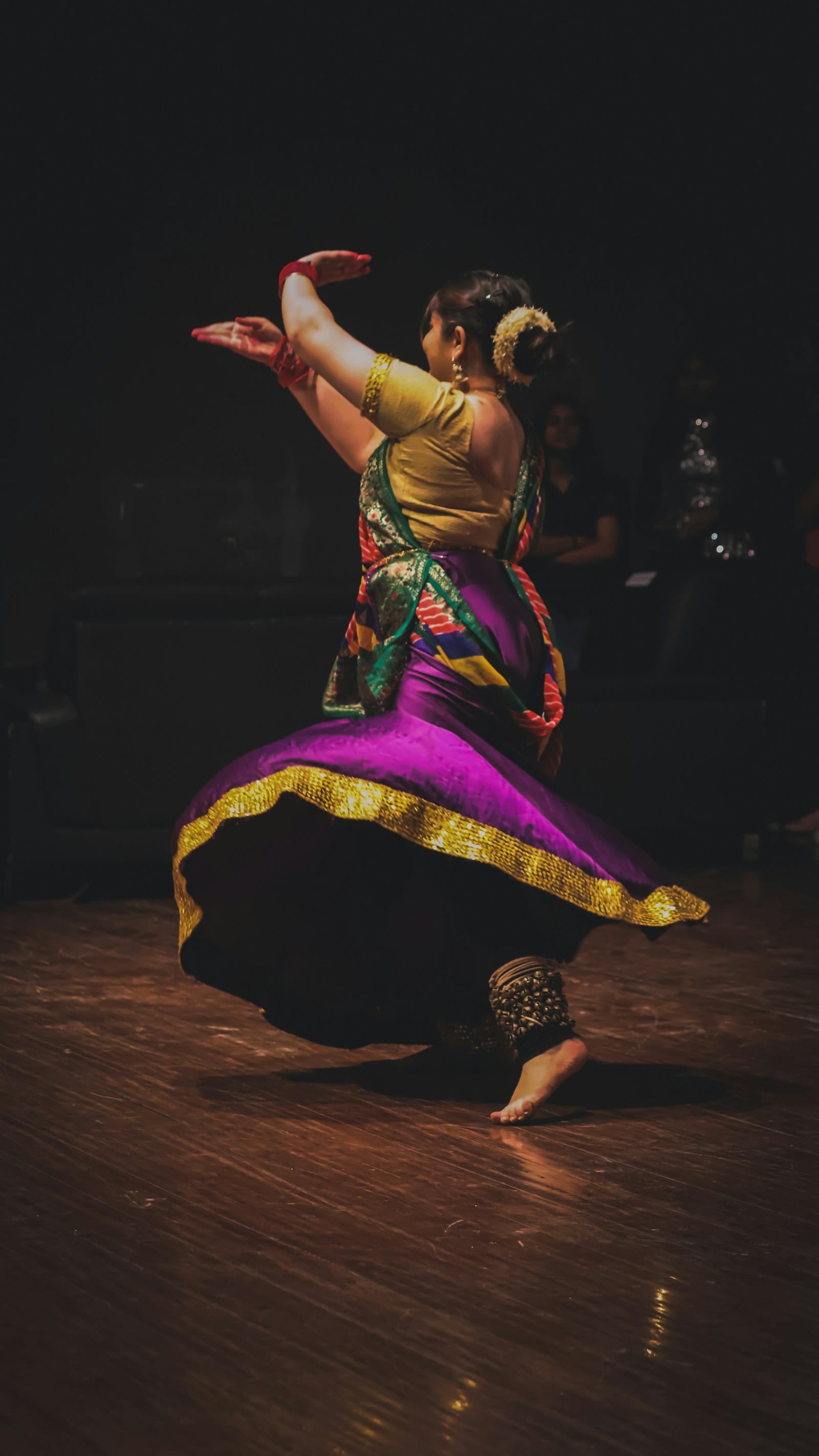 a woman is dancing on a wooden floor